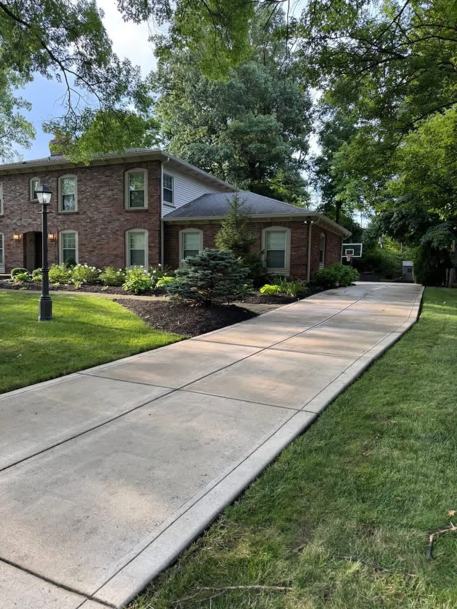 Pressure-washed driveway in front of a brick house